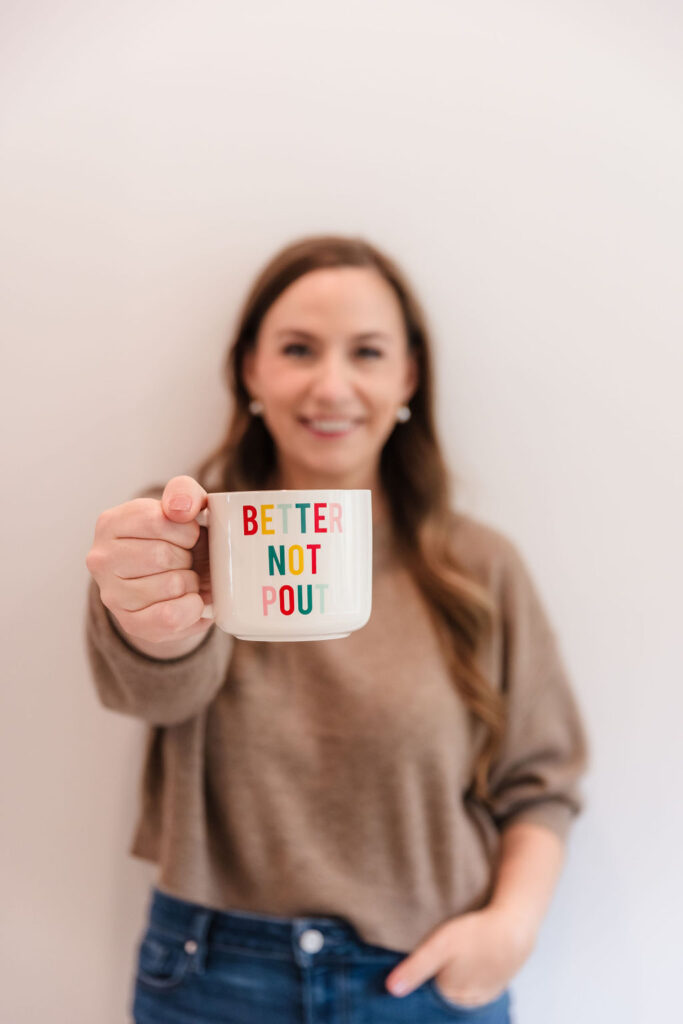 Woman holding coffee cup that says Better Not Pout

