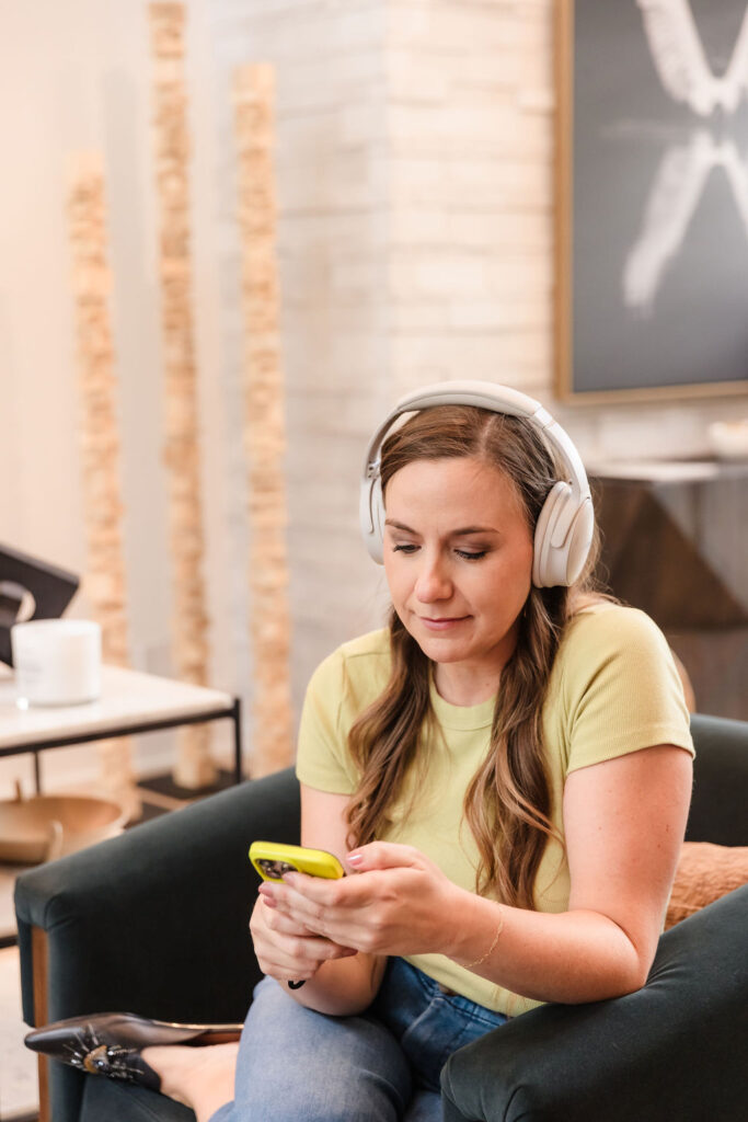Woman with headphones on and looking at cell phone
